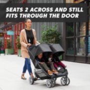 mom pushing kids in city mini 2 double stroller seats 2 across and still fits through the door image number 1