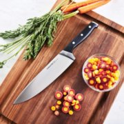 chefs knife on cutting board with cut carrots image number 7