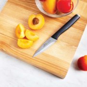 cut peach on cutting board with paring knife image number 5