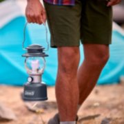 man holding lantern with handle outdoors image number 7