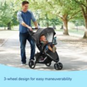 Male-presenting person pushing baby in a jogger image number 1