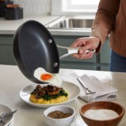 Person sliding food onto plate from pan image number 3
