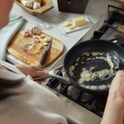Person sautéing garlic in pan on stovetop image number 3