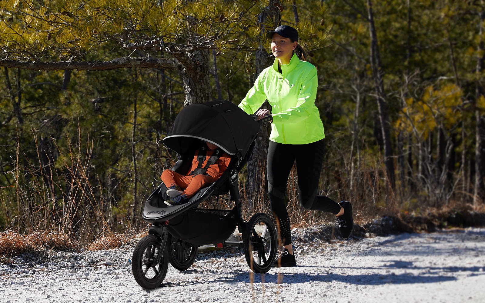 woman jogging with child inside jogger stroller