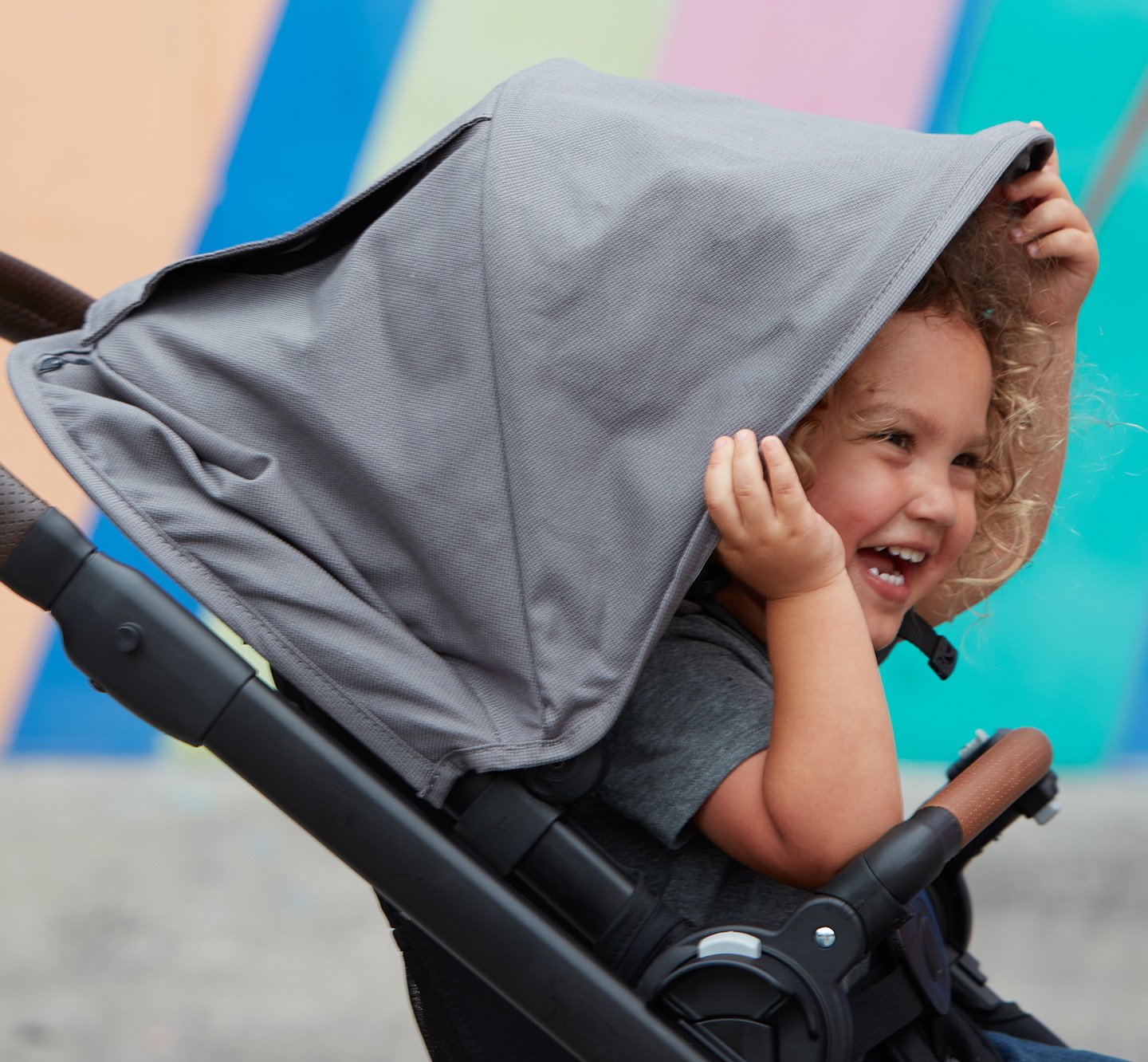 child in baby stroller, laughing