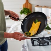 Person sliding food onto plate from pan image number 5