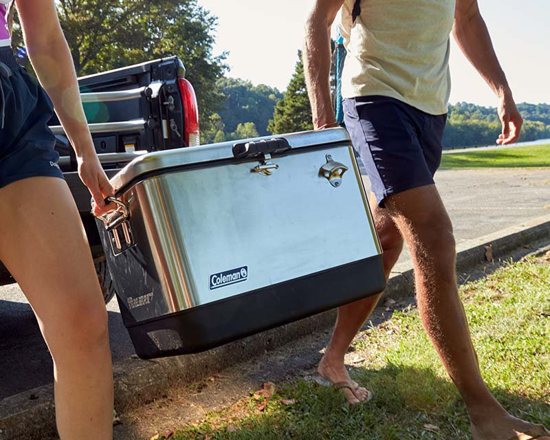 Two people carrying a cooler