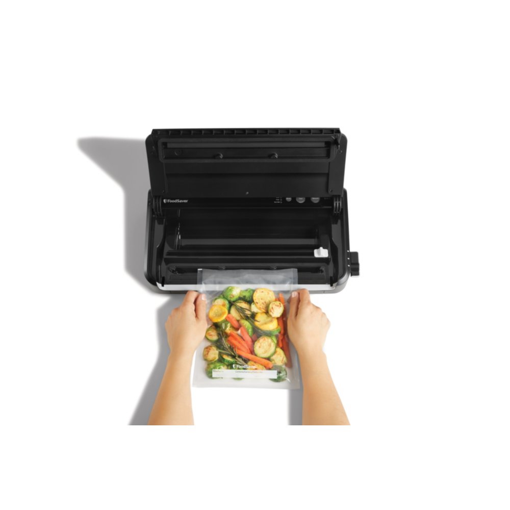 https://newellbrands.scene7.com/is/image/NewellRubbermaid/SAP-foodsaver-FM2900-step-1-with-food-overhead-with-talent-1_White?wid=1000&hei=1000